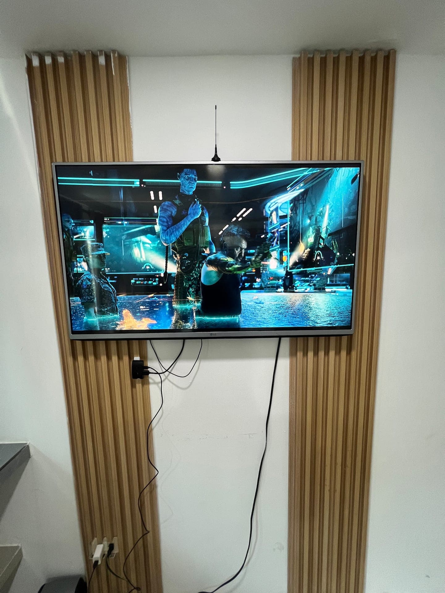 Televisor de pantalla plana sobre panel de listones de madera